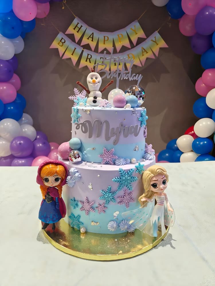 Two-tier Frozen-theme birthday cake in lilac and blue with snowflakes and figurines